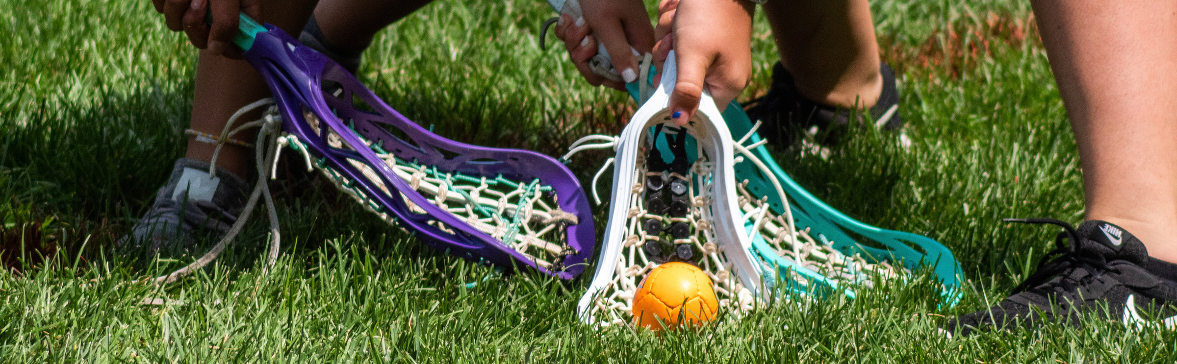 Lacrosse players scooping a Swax Lax practice ball while doing lacrosse drills